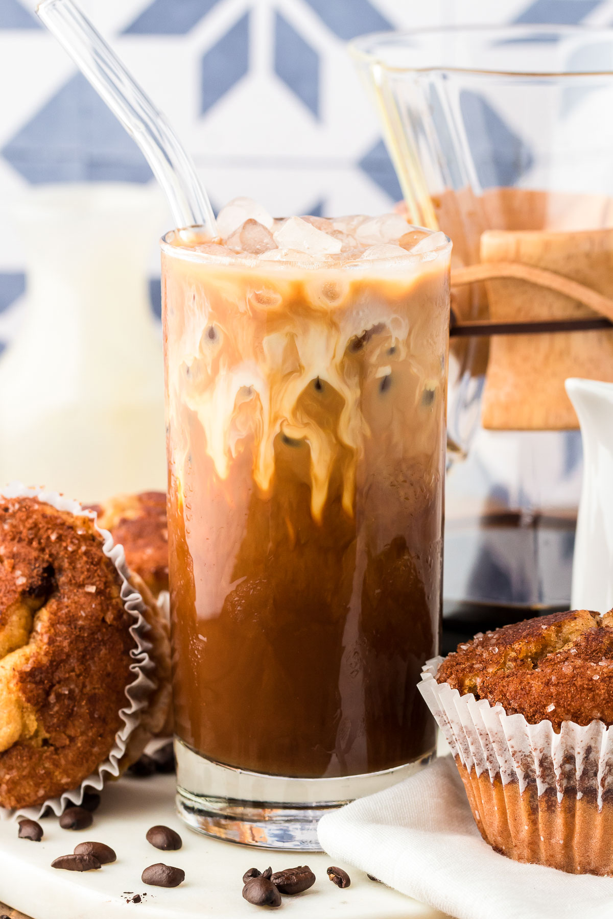 A glass filled with Thai iced coffee on a white table.