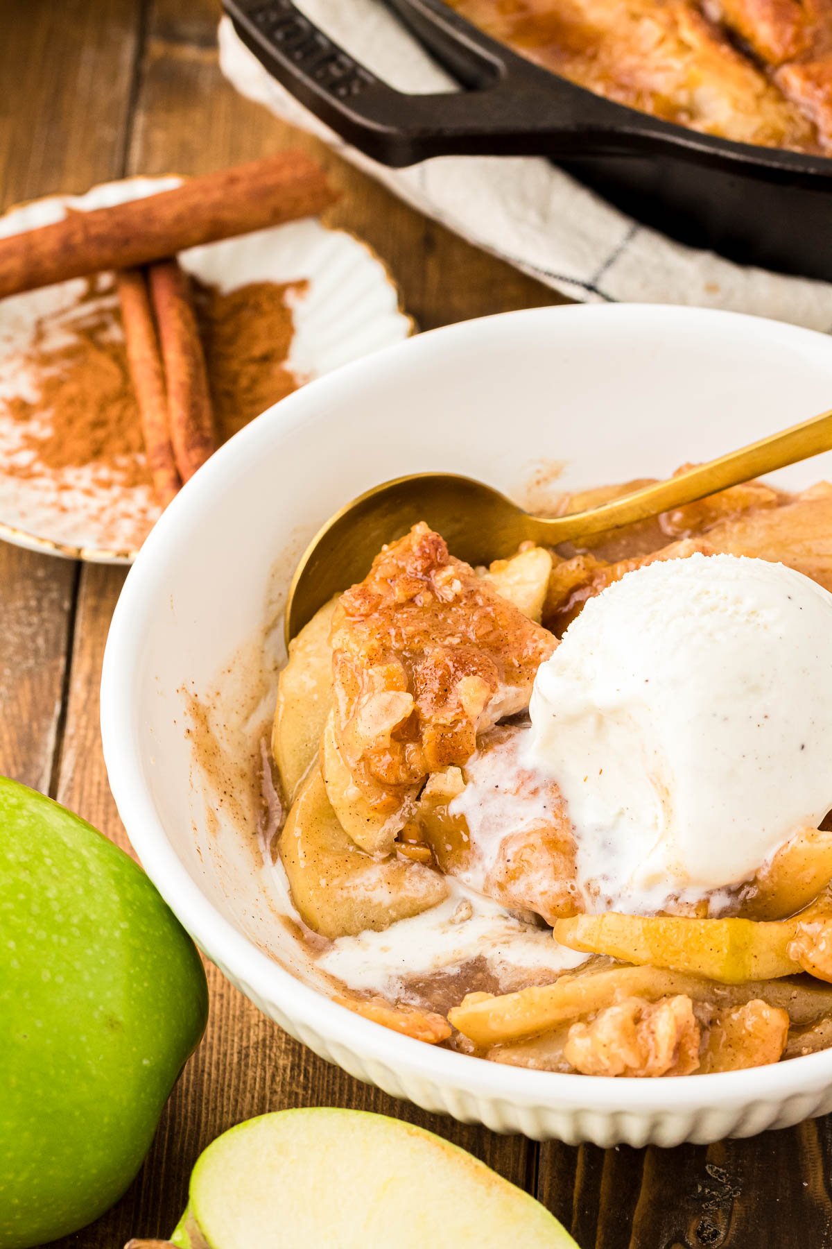 A white bowl with apple pan dowdy and ice cream in it.