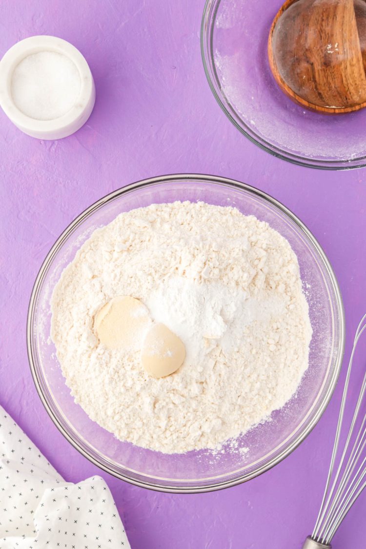 Dry ingredients to make cookies in a glass mixing bowl.