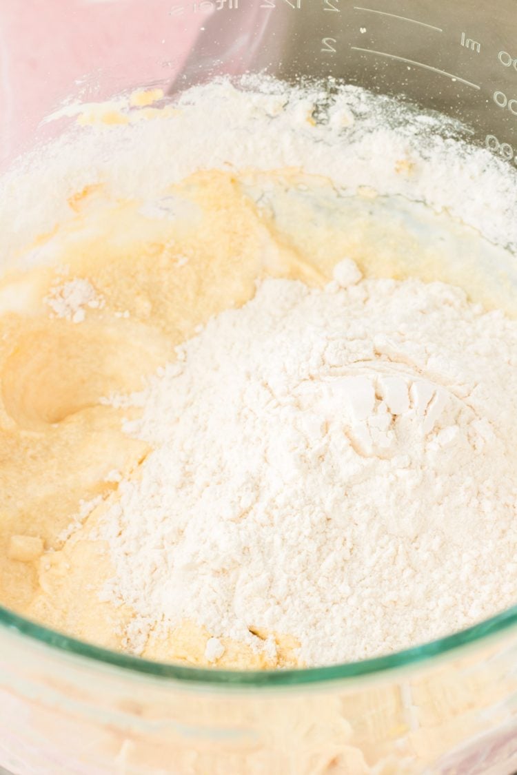 Dry ingredients being added to a bowl of cake batter.