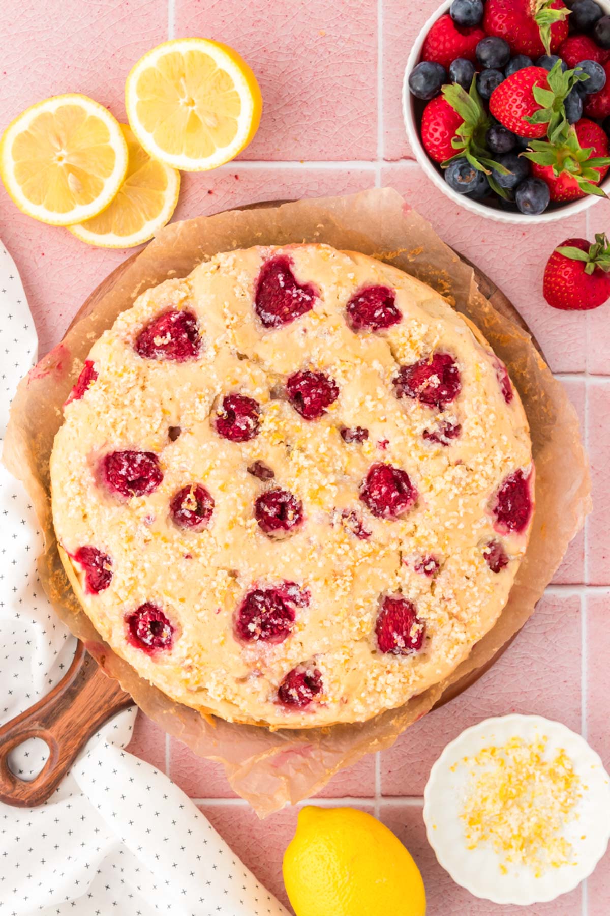 Overhead photo of lemon raspberry cake on a serving board.
