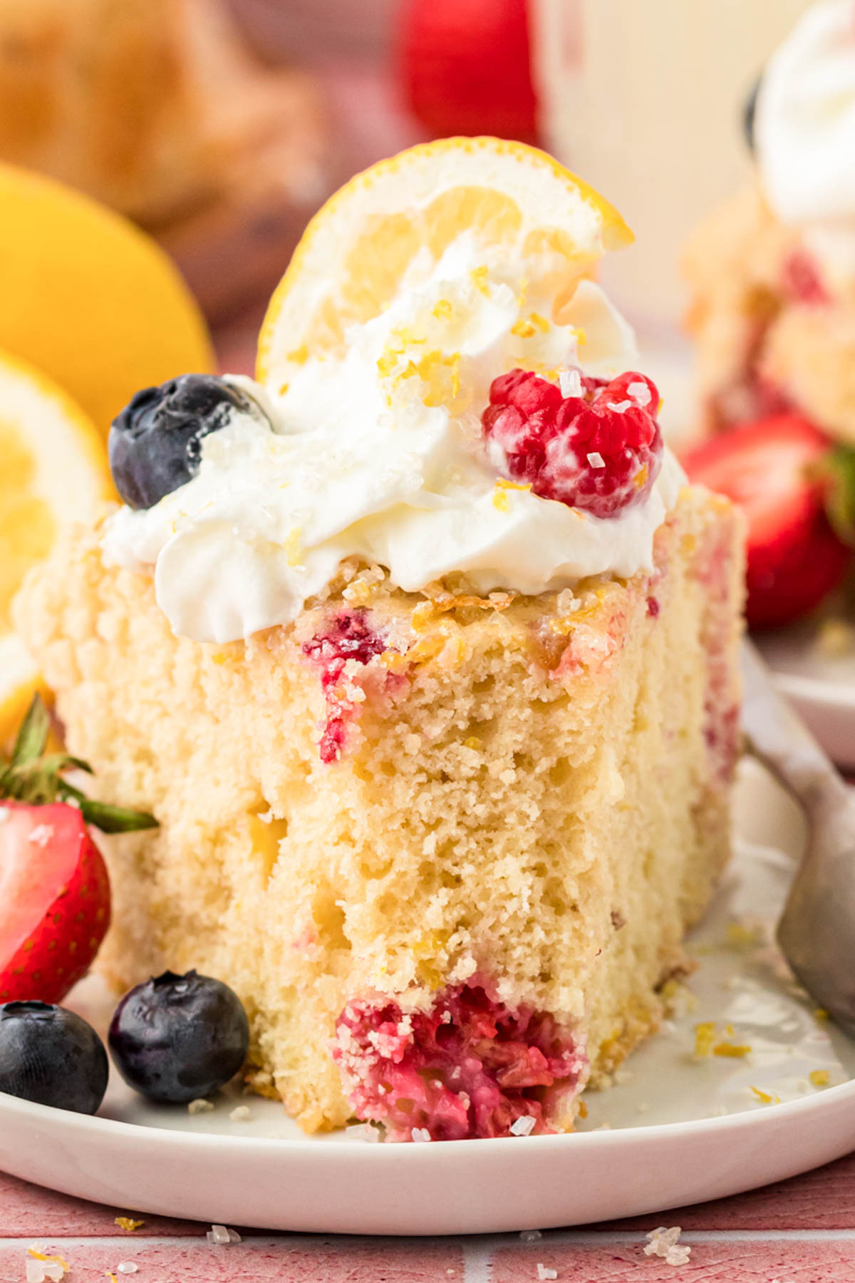 A slice of lemon raspberry cake on a small white plate.