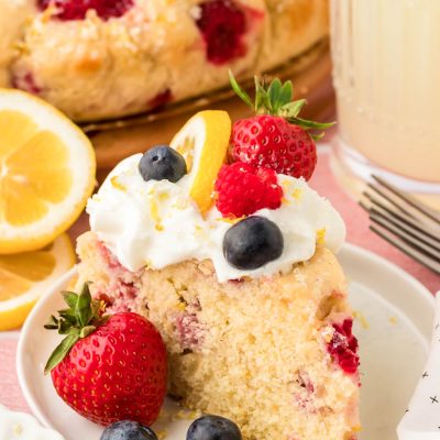 A slice of lemon raspberry cake on a white plate.