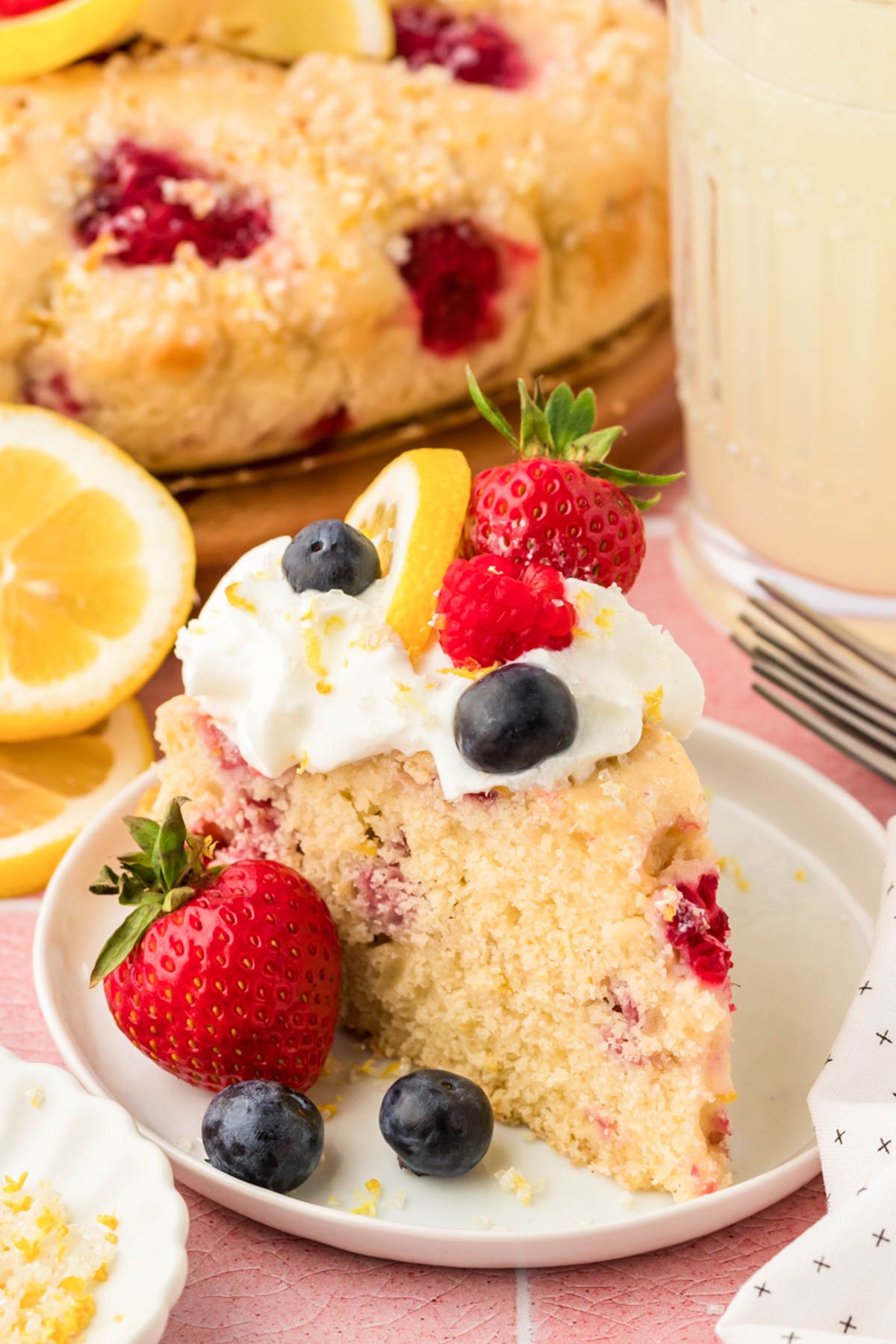 A slice of lemon raspberry cake on a white plate.