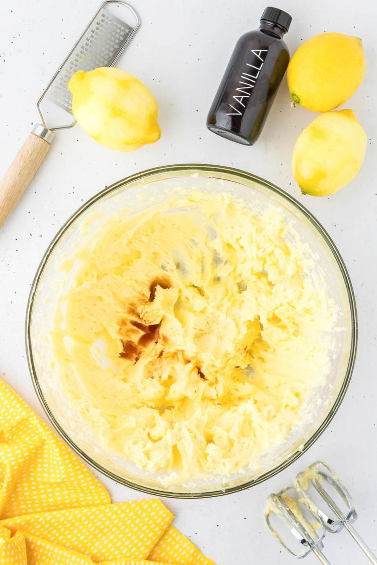 Vanilla extract being added to a bowl of creamed butter and sugar.