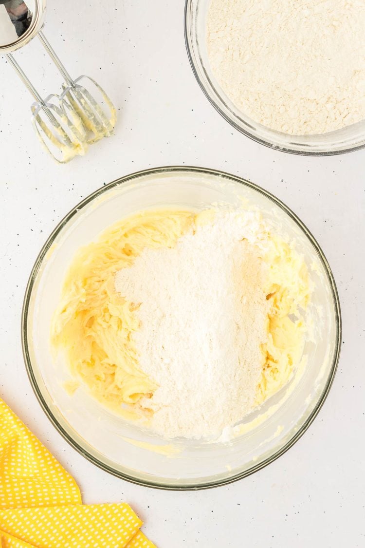 Flour being added to creamed butter and sugar.