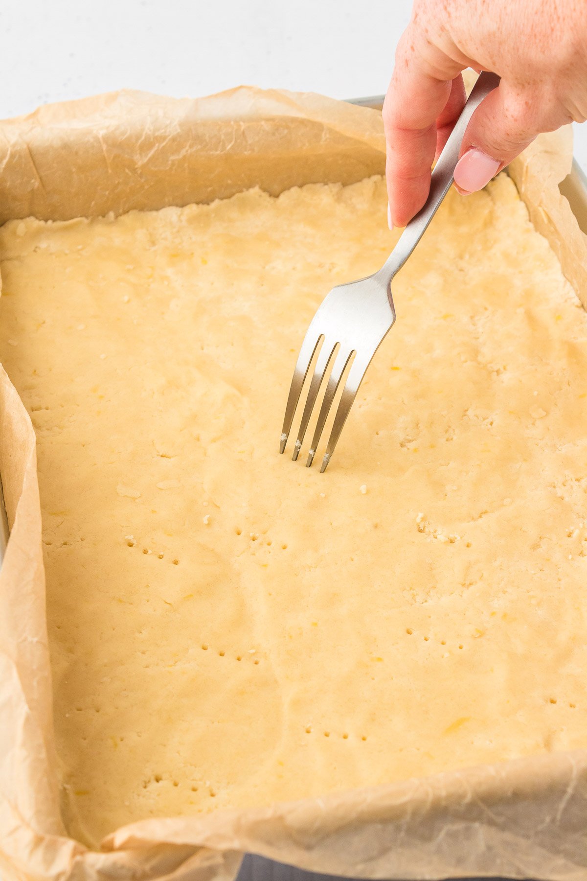 A fork pricking shortbread all over before baking.