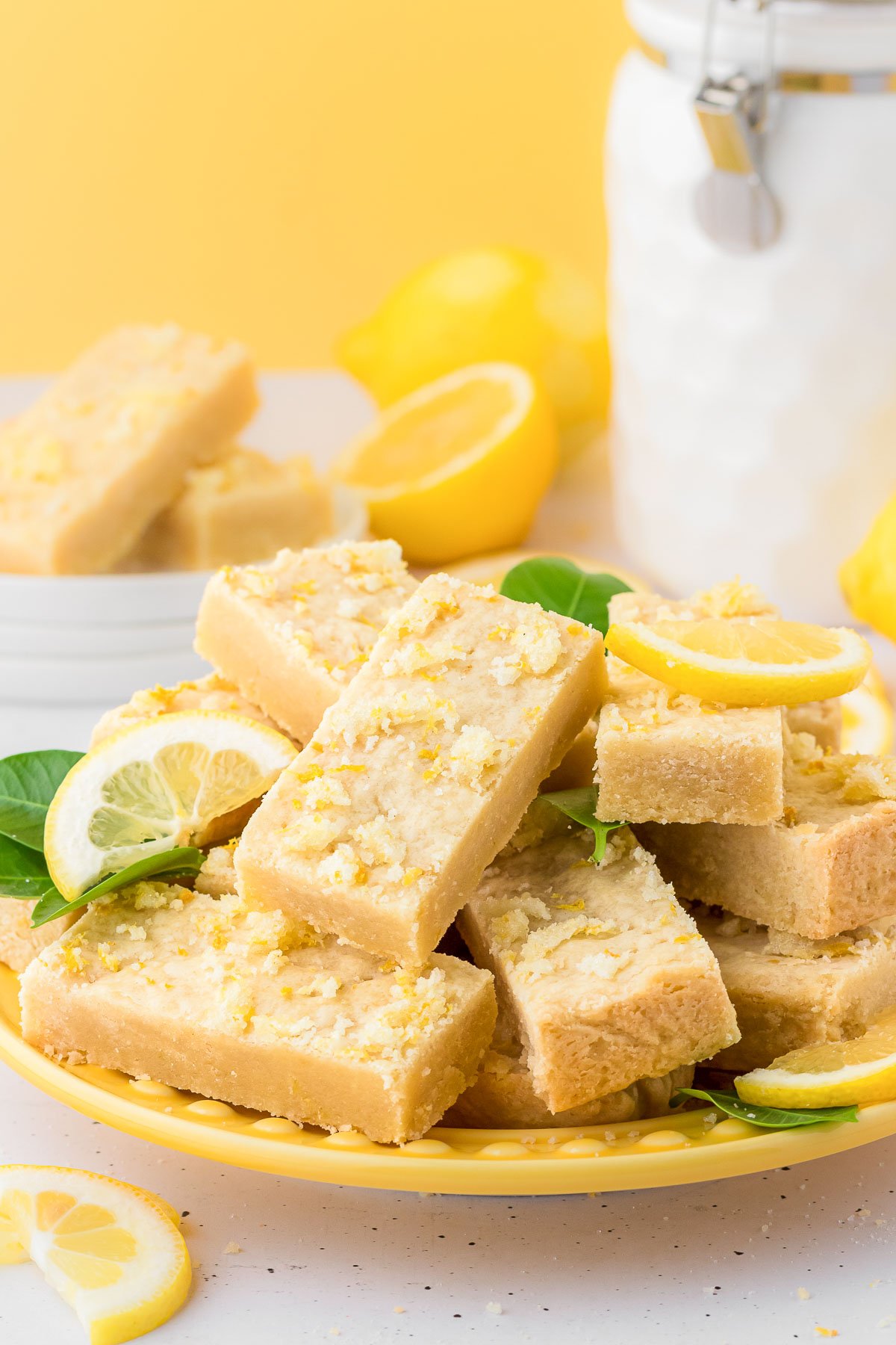 A yellow plate filled with lemon shortbread bars.