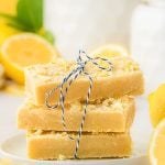 A stack of three lemon shortbread bars on a white plate.