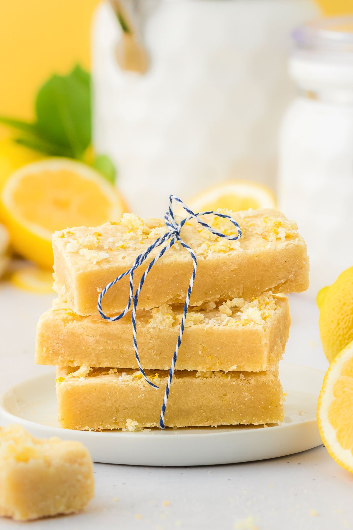 A stack of three lemon shortbread bars on a white plate.