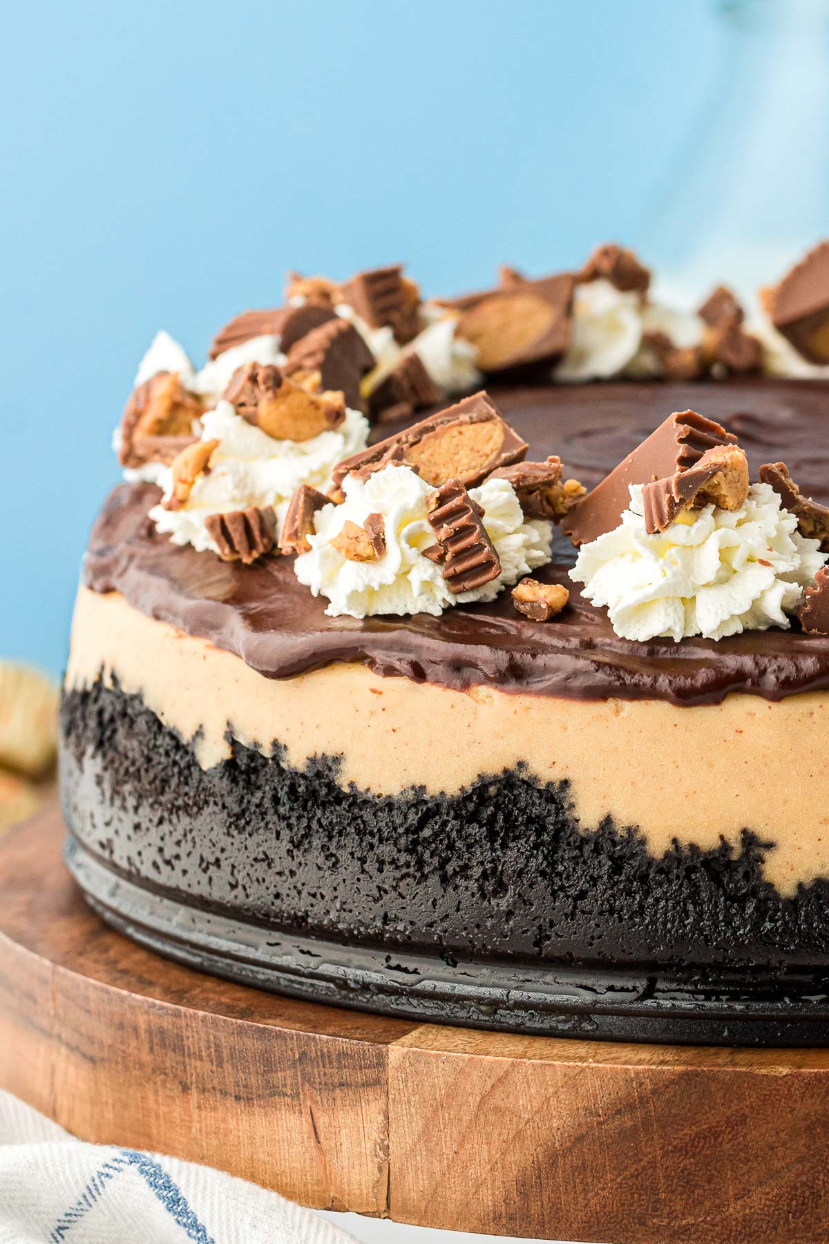 Peanut butter cheesecake on a wooden cake stand.