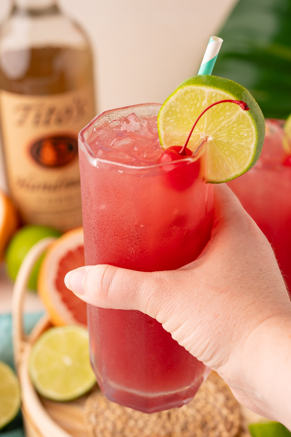 A woman's hand holding a sea breeze drink to the camera.