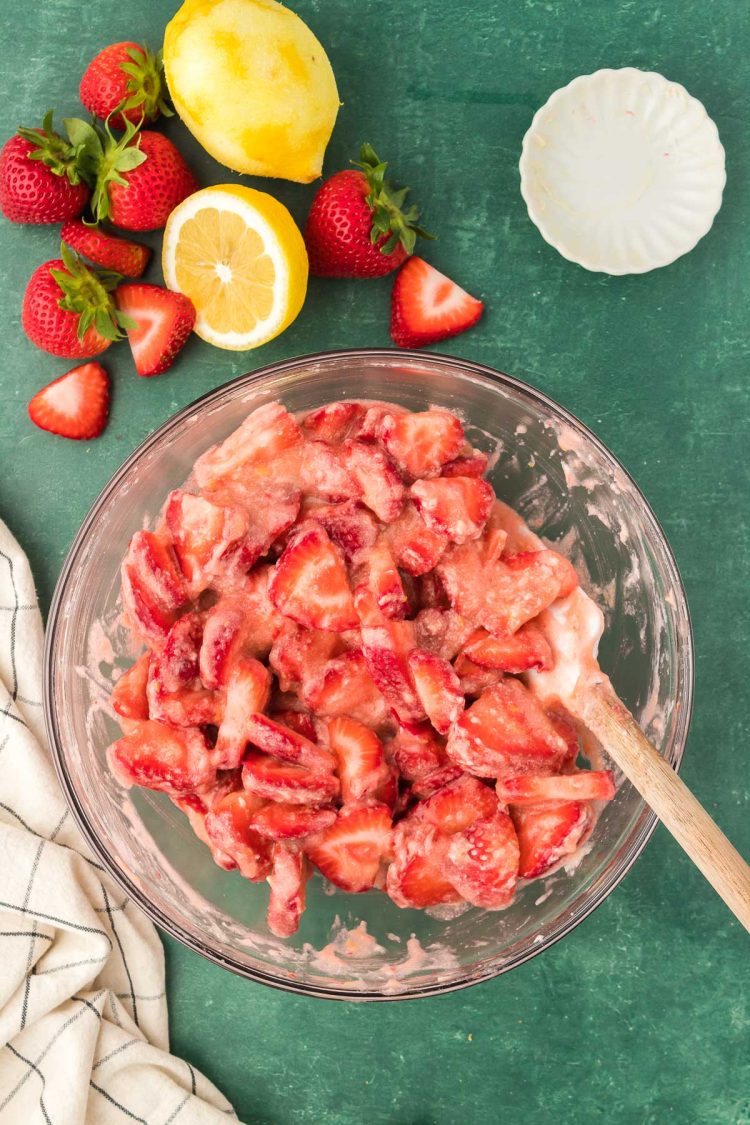 Strawberry cobbler filling being mixed in a bowl.