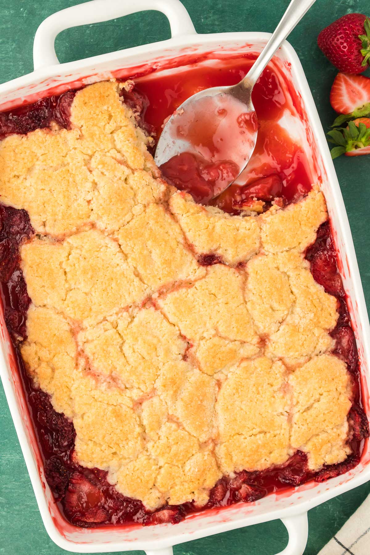 Overhead photo of strawberry cobbler with a spoon in it.
