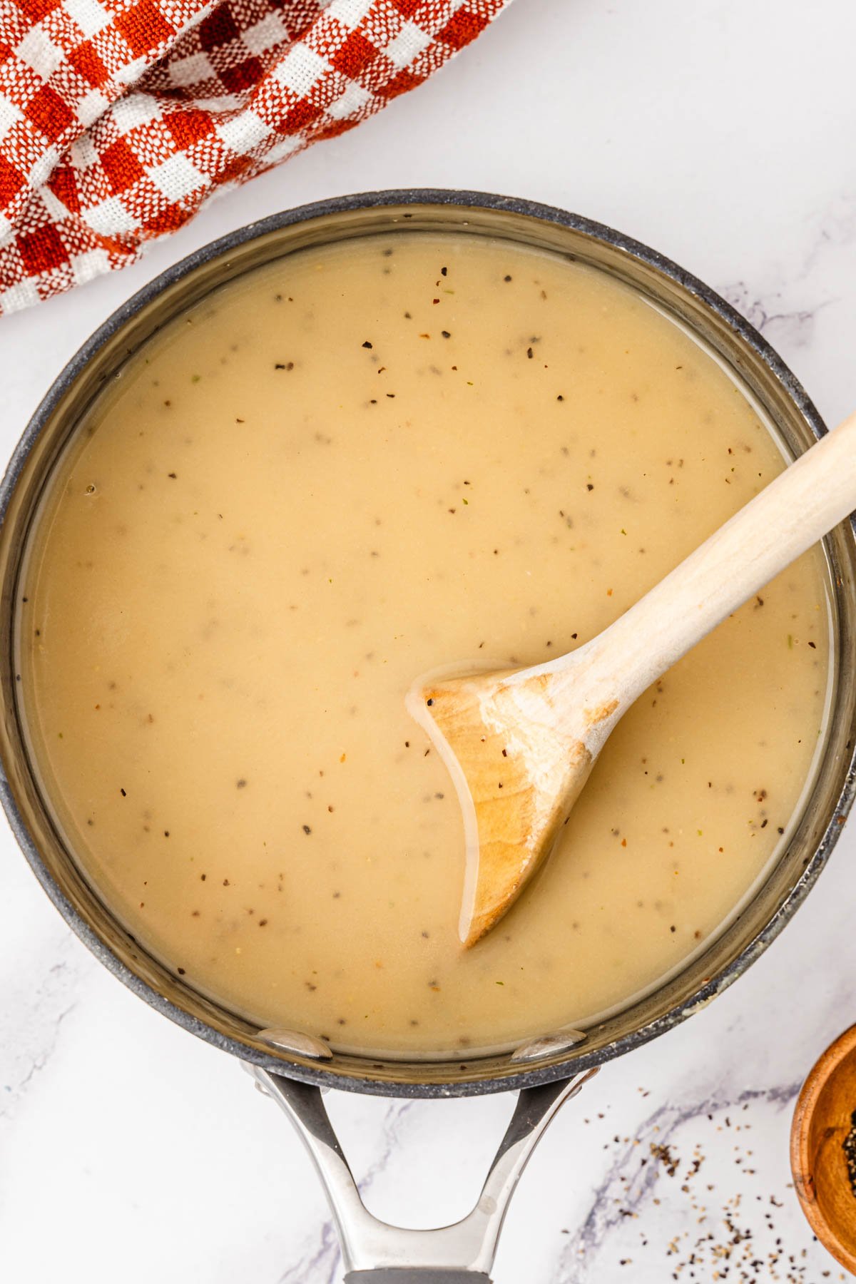 Turkey dripping gravy in a saucepan.