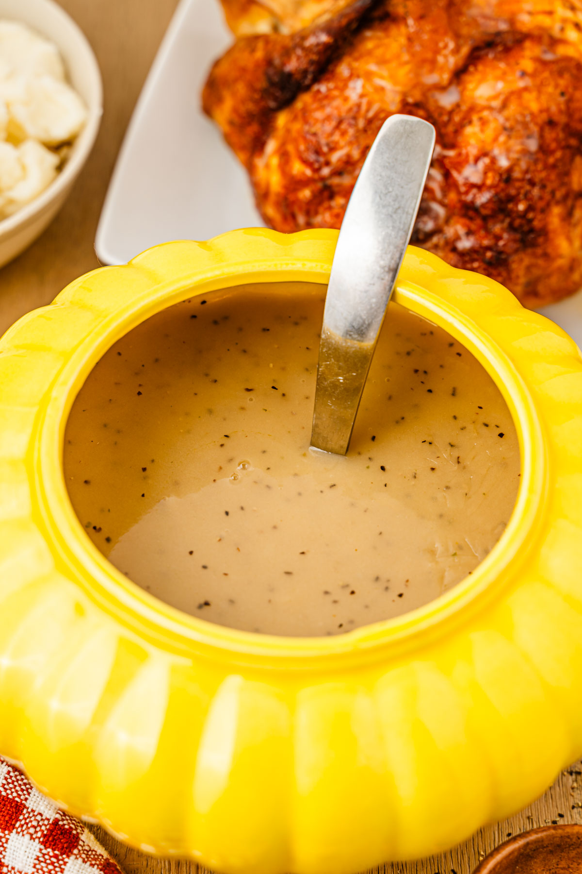 A yellow gravy boat filled with gravy.
