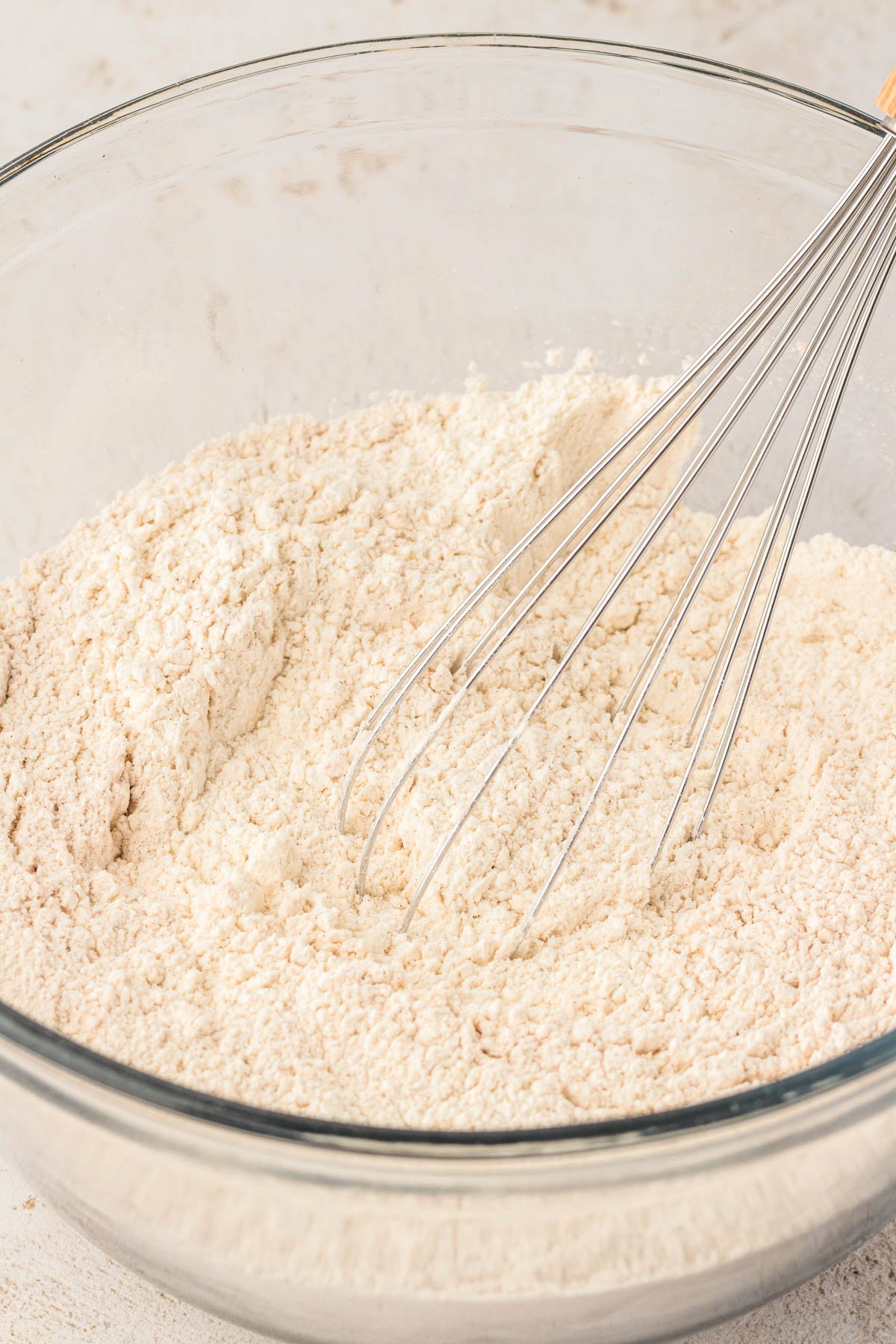 Dry ingredients for apple pie cookies being whisked in a bowl.