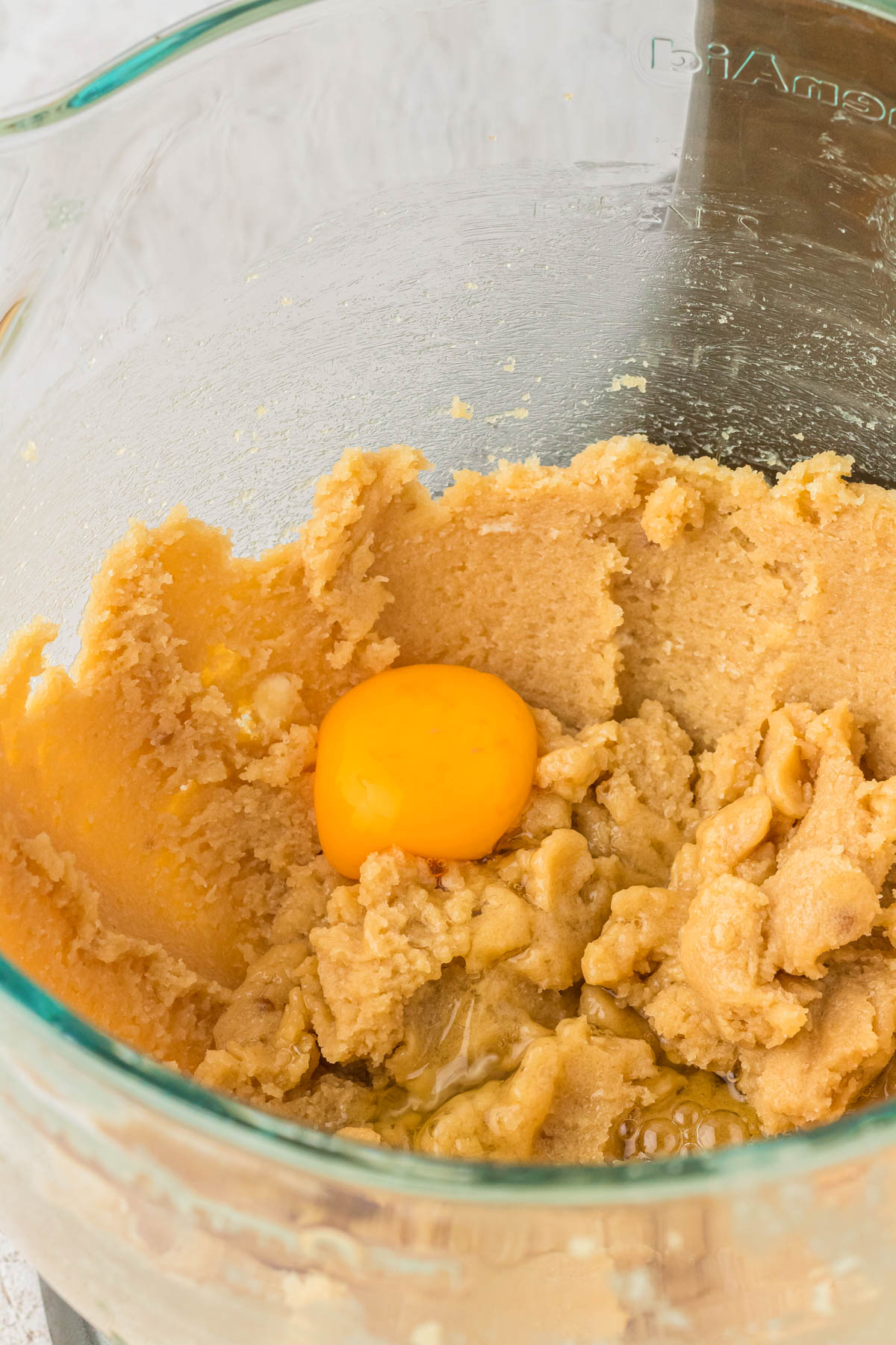 Egg being mixed into cookie dough.