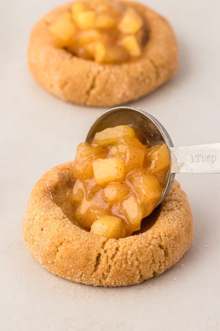 Apple pie filling being spooned into cookie dough.