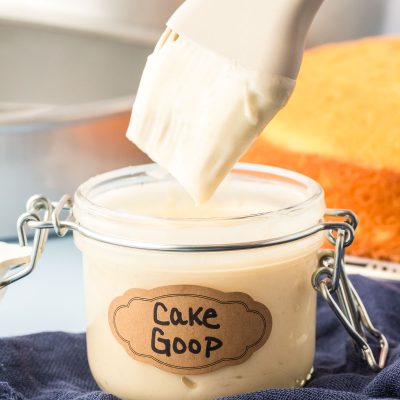 A pastry brush dipping into a jar of cake goop.