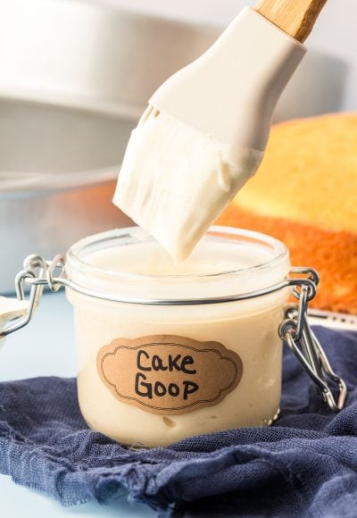 A pastry brush dipping into a jar of cake goop.