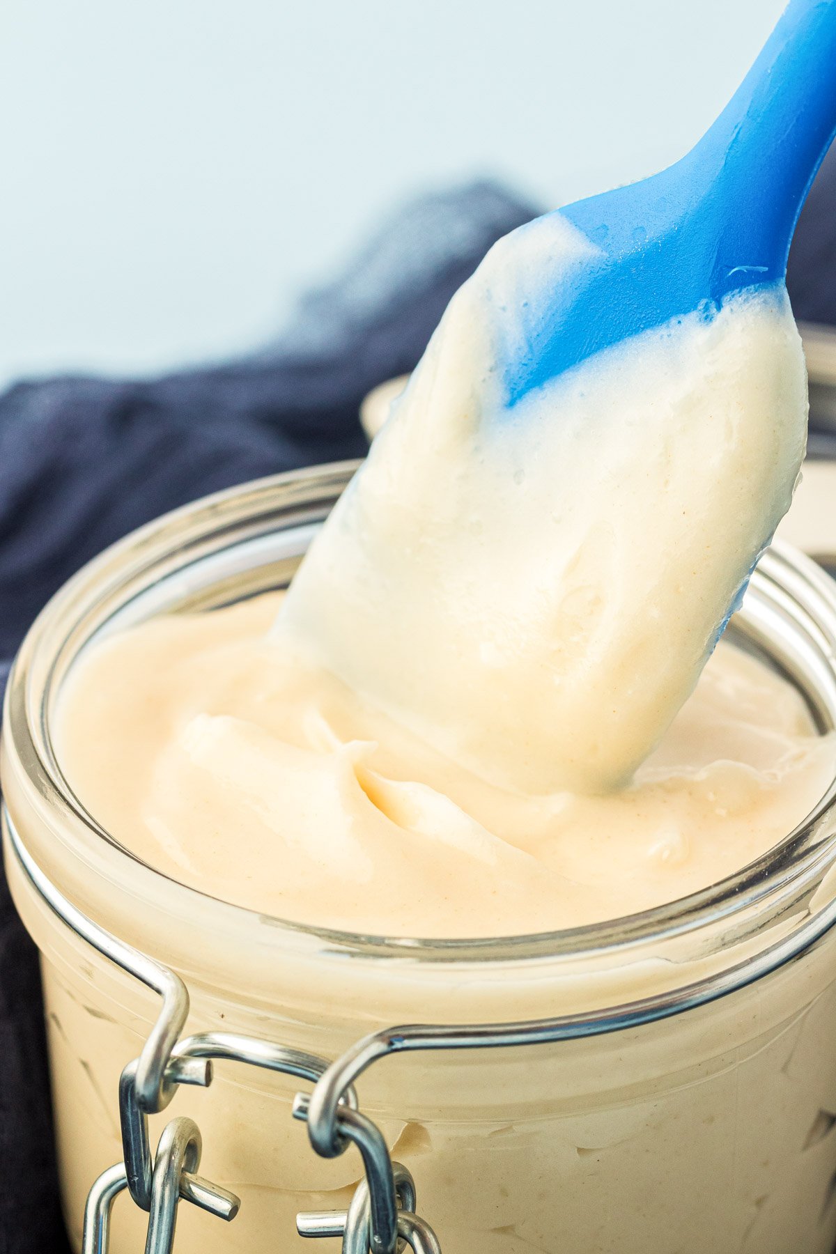 A pastry brush dipping into a jar of cake goop.