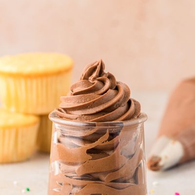 Chocolate Cream Cheese Frosting piped into a glass jar.