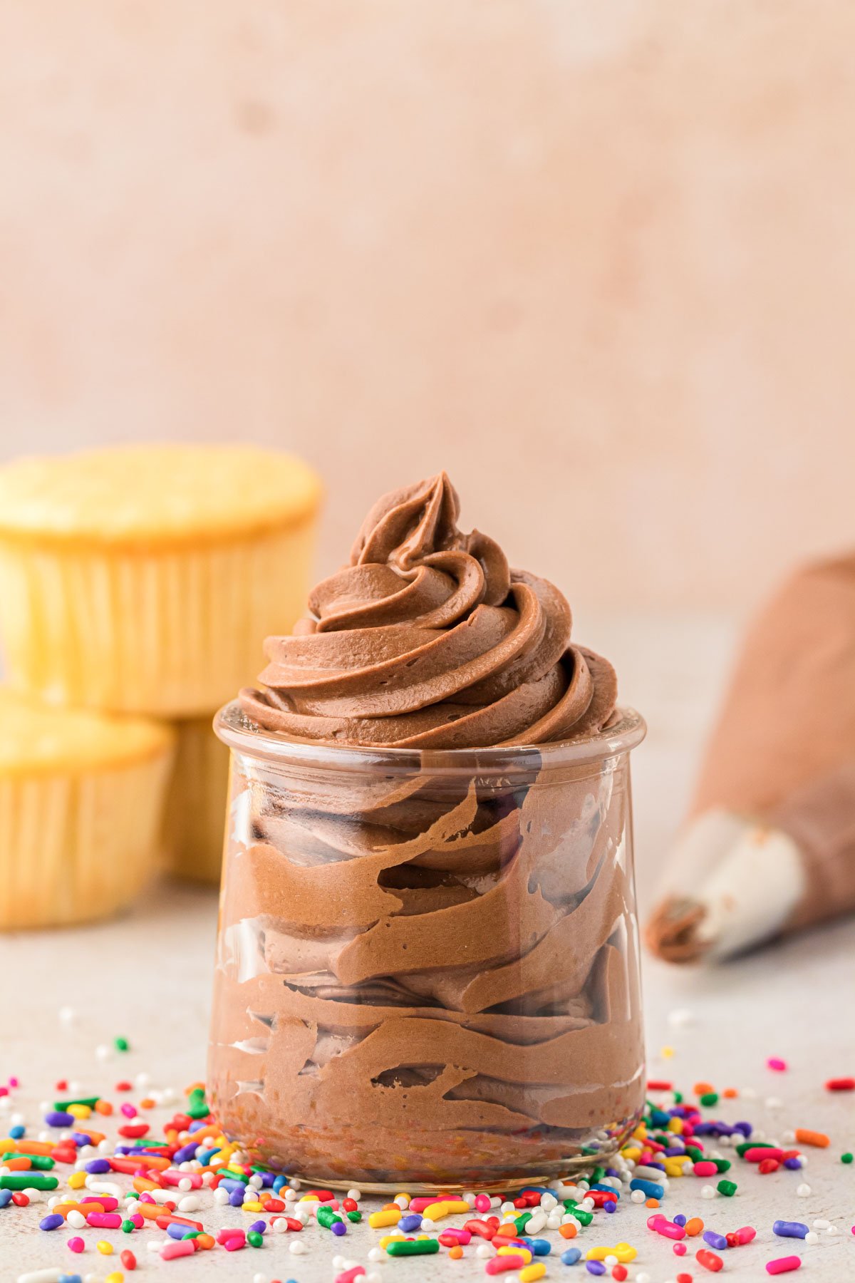 Chocolate Cream Cheese Frosting piped into a glass jar.