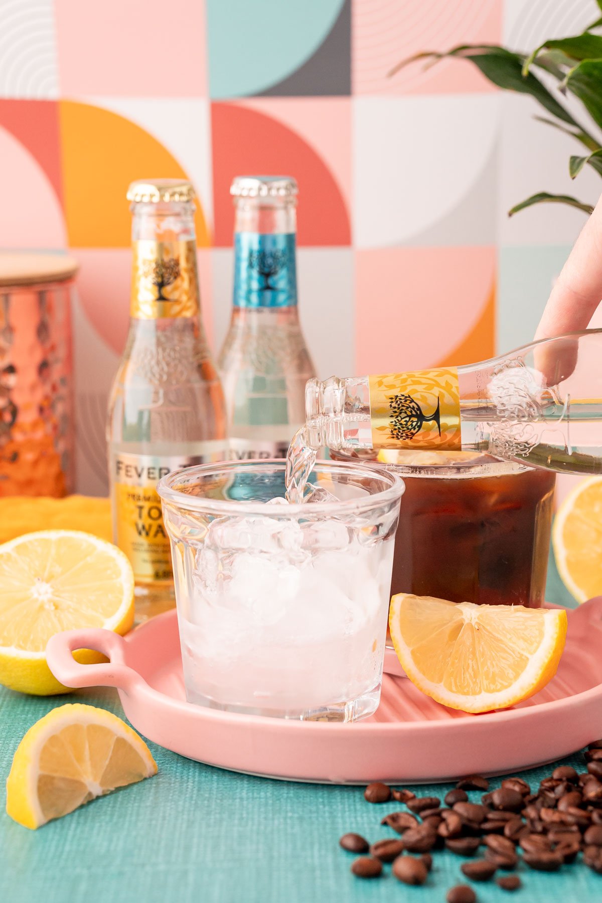 Tonic water being poured into a glass with ice.