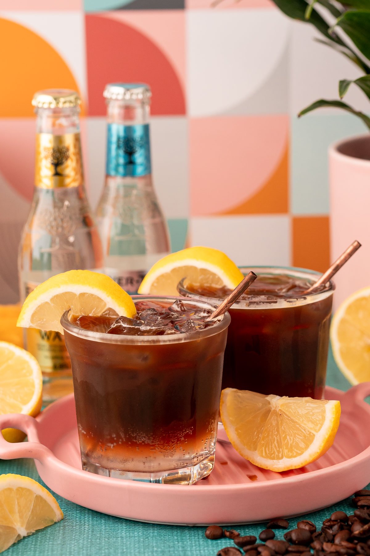 Two glasses of espresso with tonic water on a pink tray.