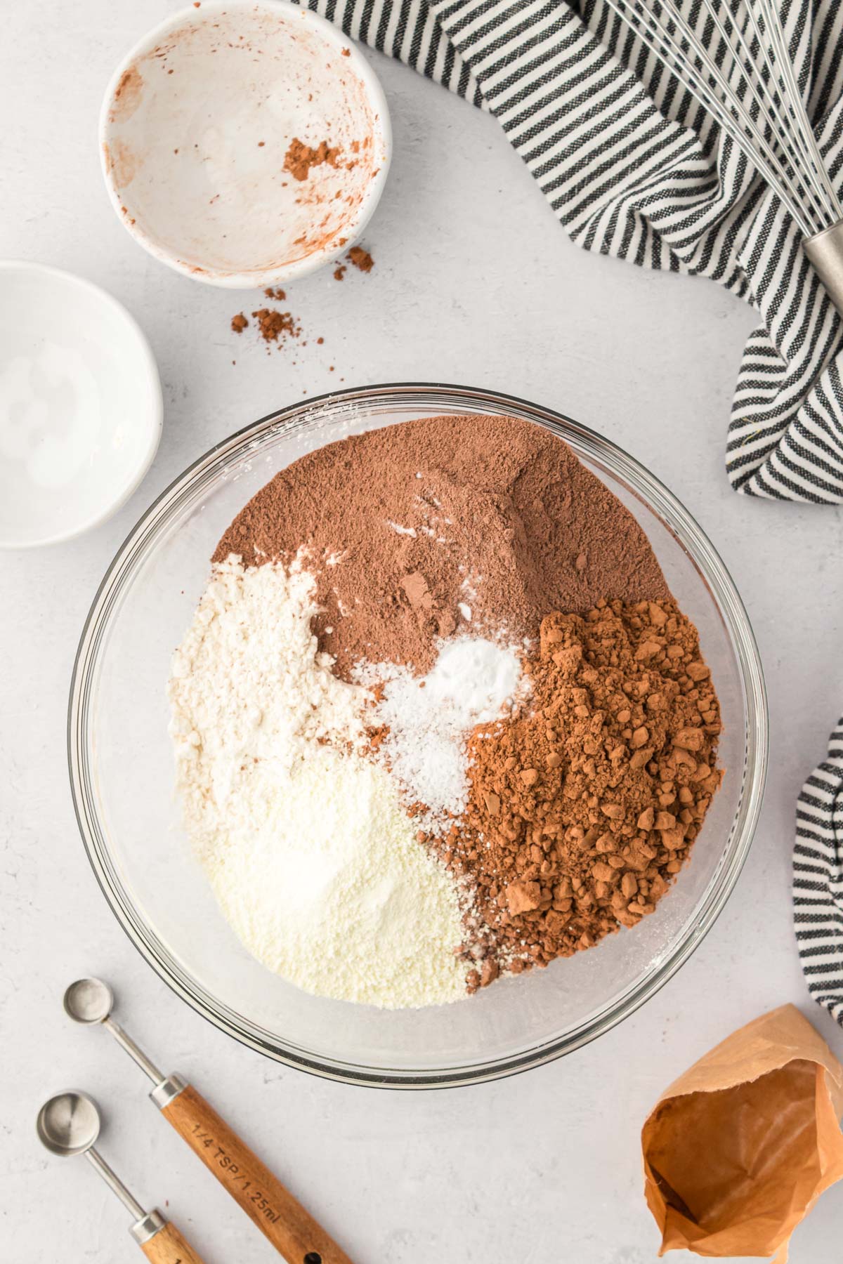 Dry ingredients to make chocolate cookies in a glass mixing bowl.