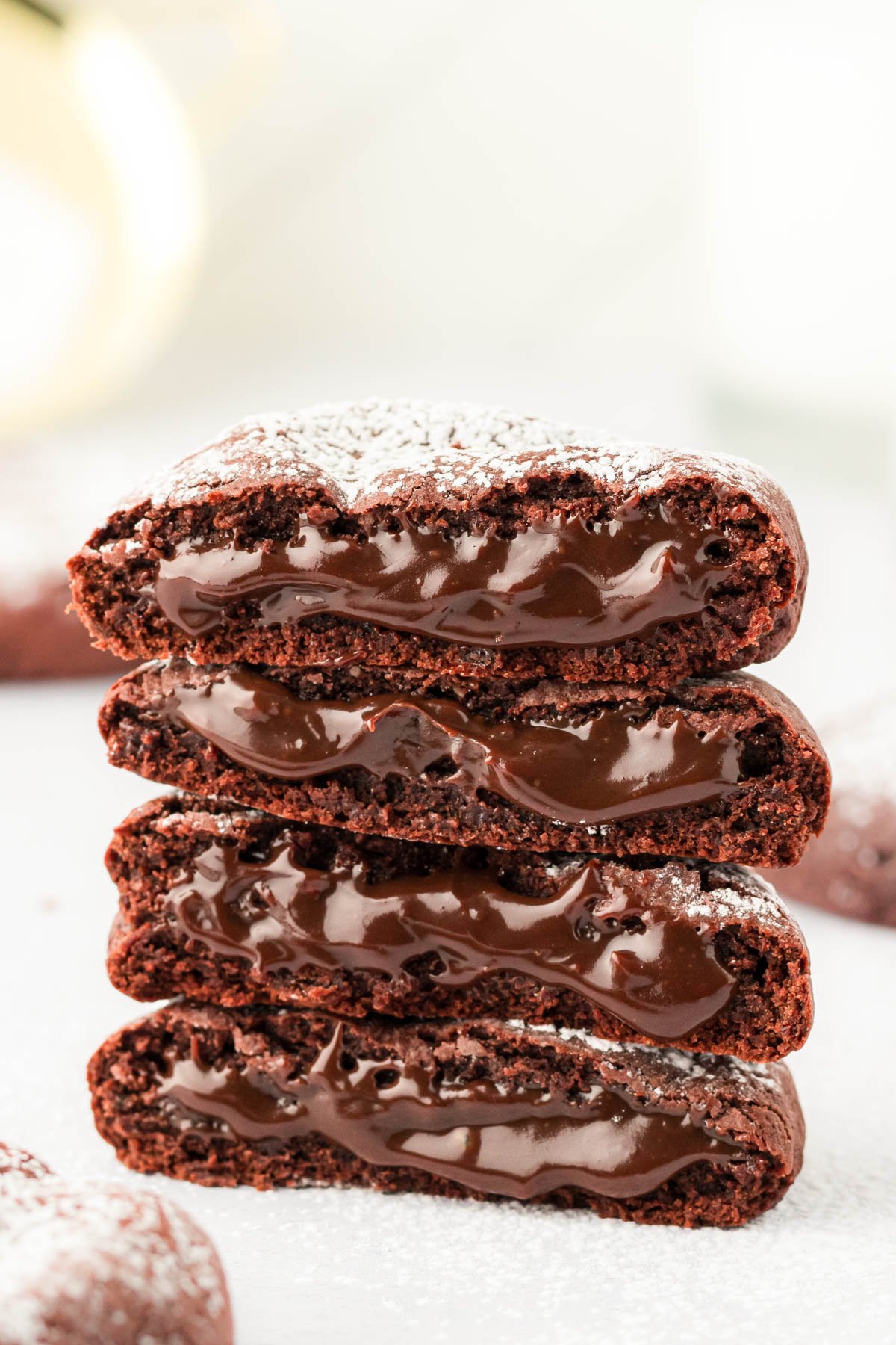 A stack of molten lava cake cookies on a white surface. 