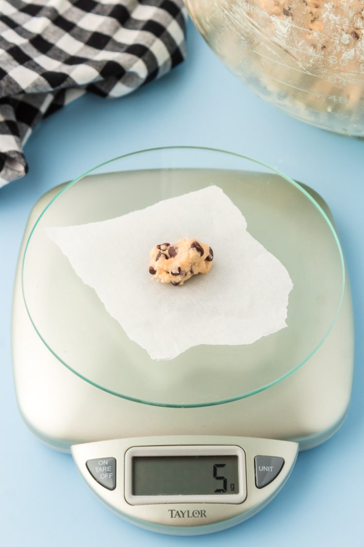 Cookie dough being portioned out of a kitchen scale to make itty bitty chocolate chip cookies.