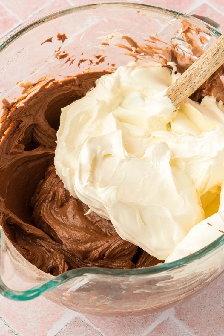 Cool whip being folded into chocolate cheesecake filling.