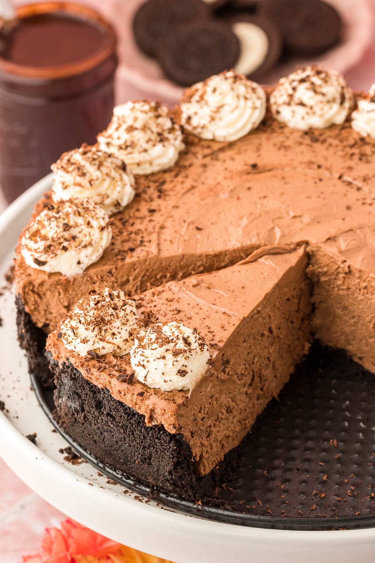 A slice of no bake chocolate cheesecake on a pan with more cheesecake.