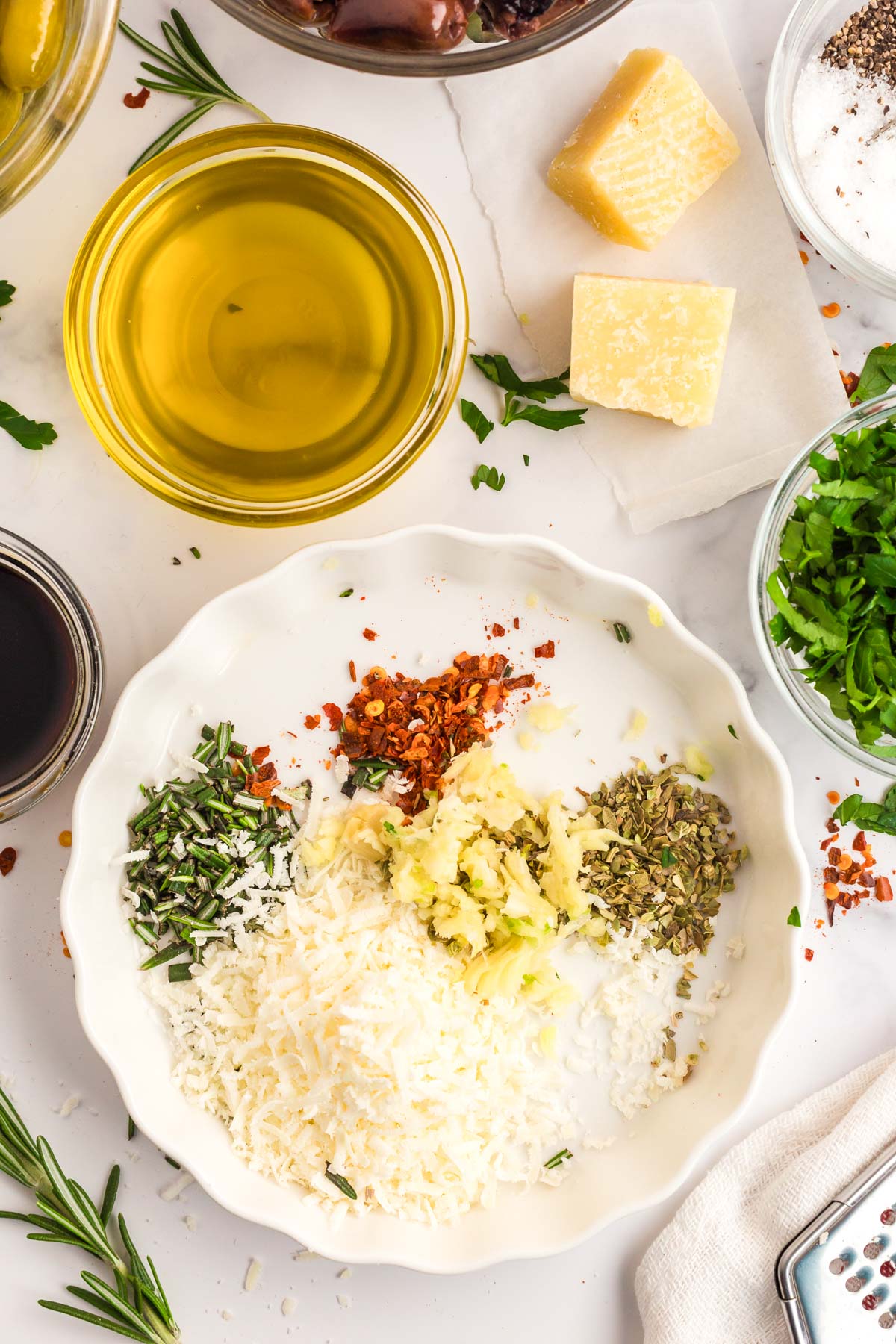 Overhead photo of herbs, spices, and parmesan cheese in a small bowl.