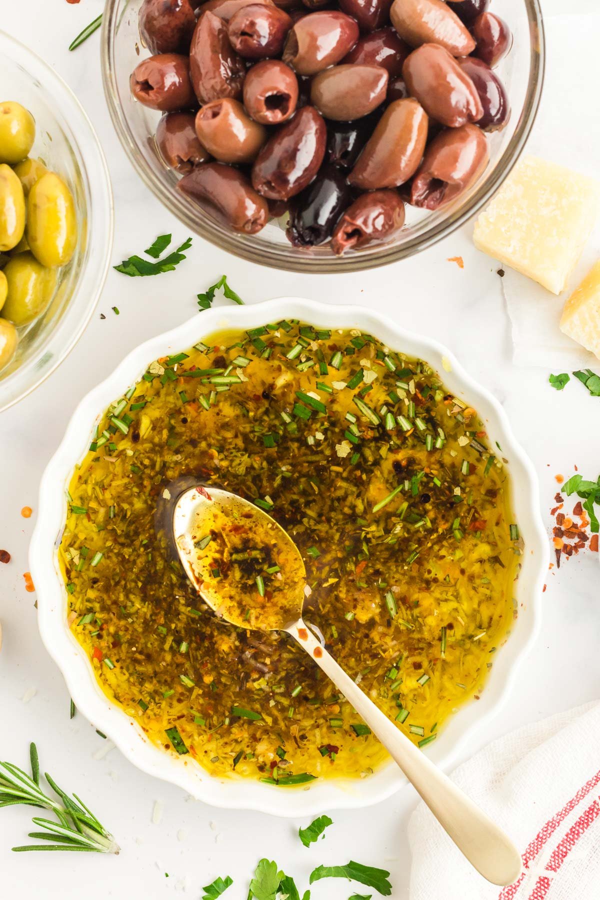 Overhead photo of a white dish with olive oil bread dip with a spoon in it.