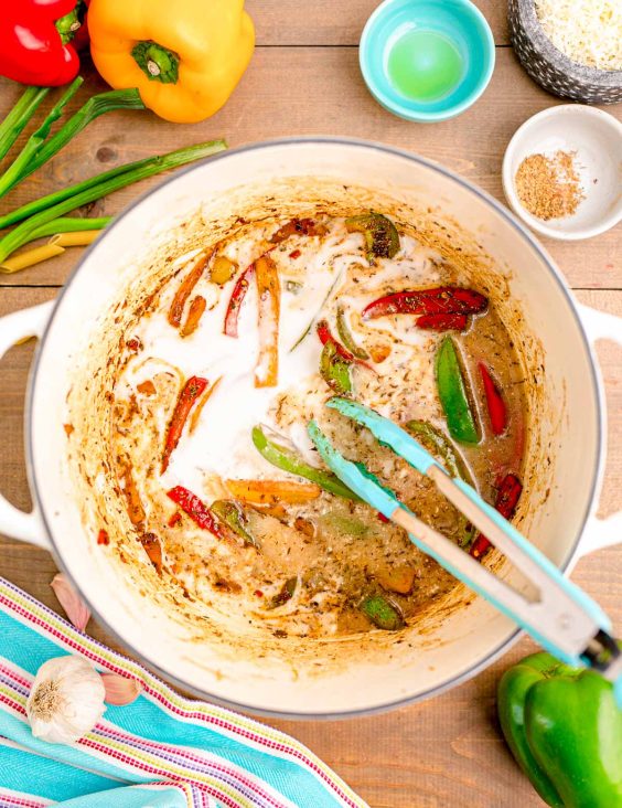 Coconut milk and peppers and seasoning in a Dutch oven.