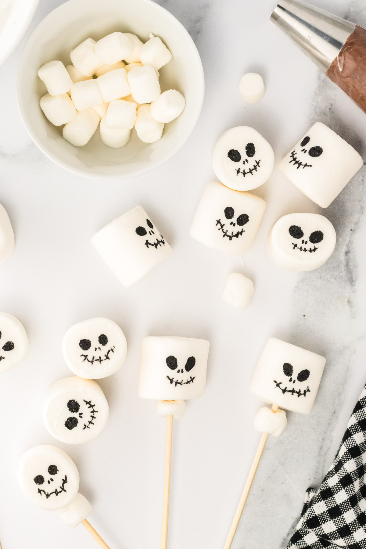 Faces being drawn on marshmallows with edible marker.