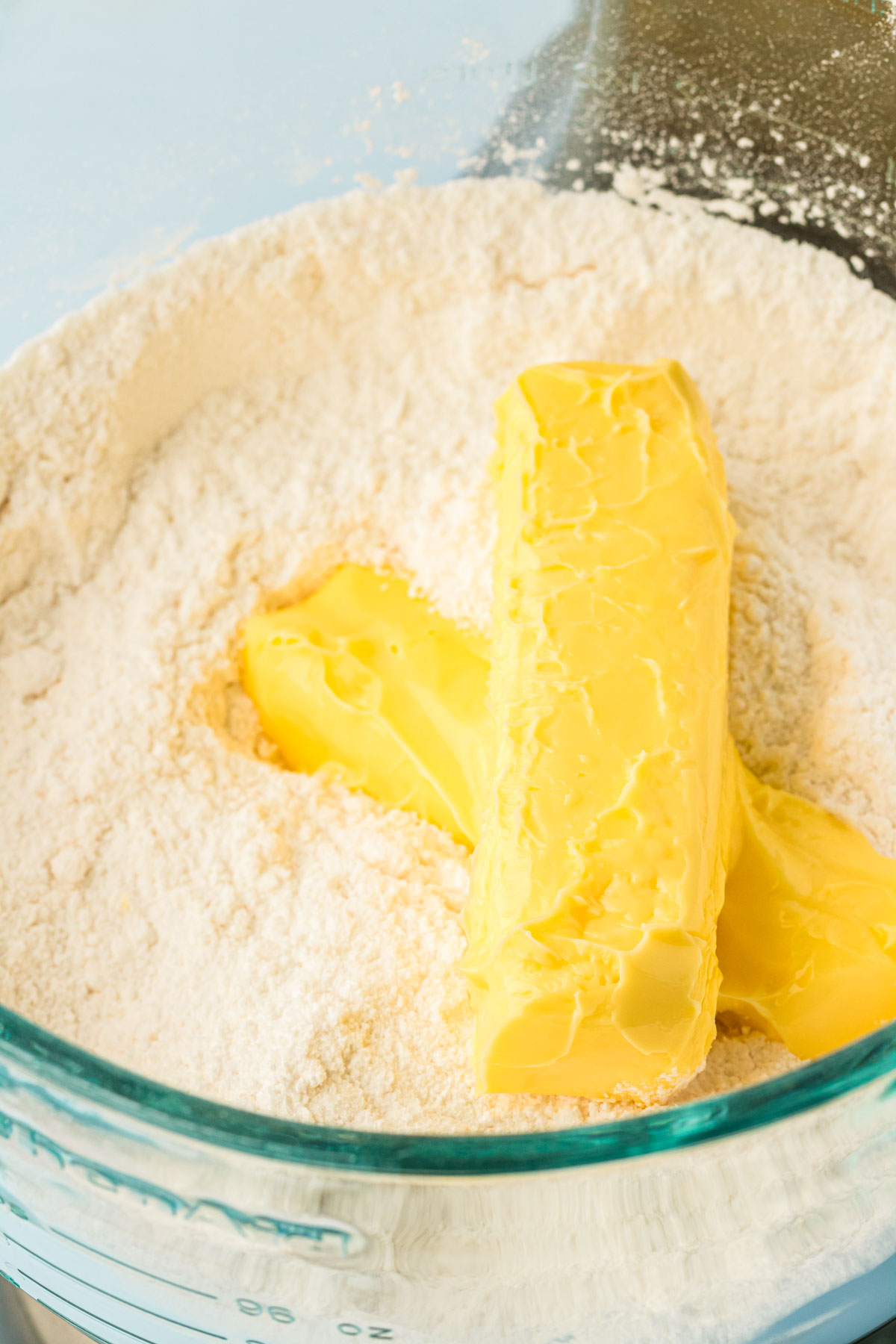 Butter being added to dry ingredients to make cake.