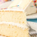 Close up of a piece of vanilla cake on a white plate.