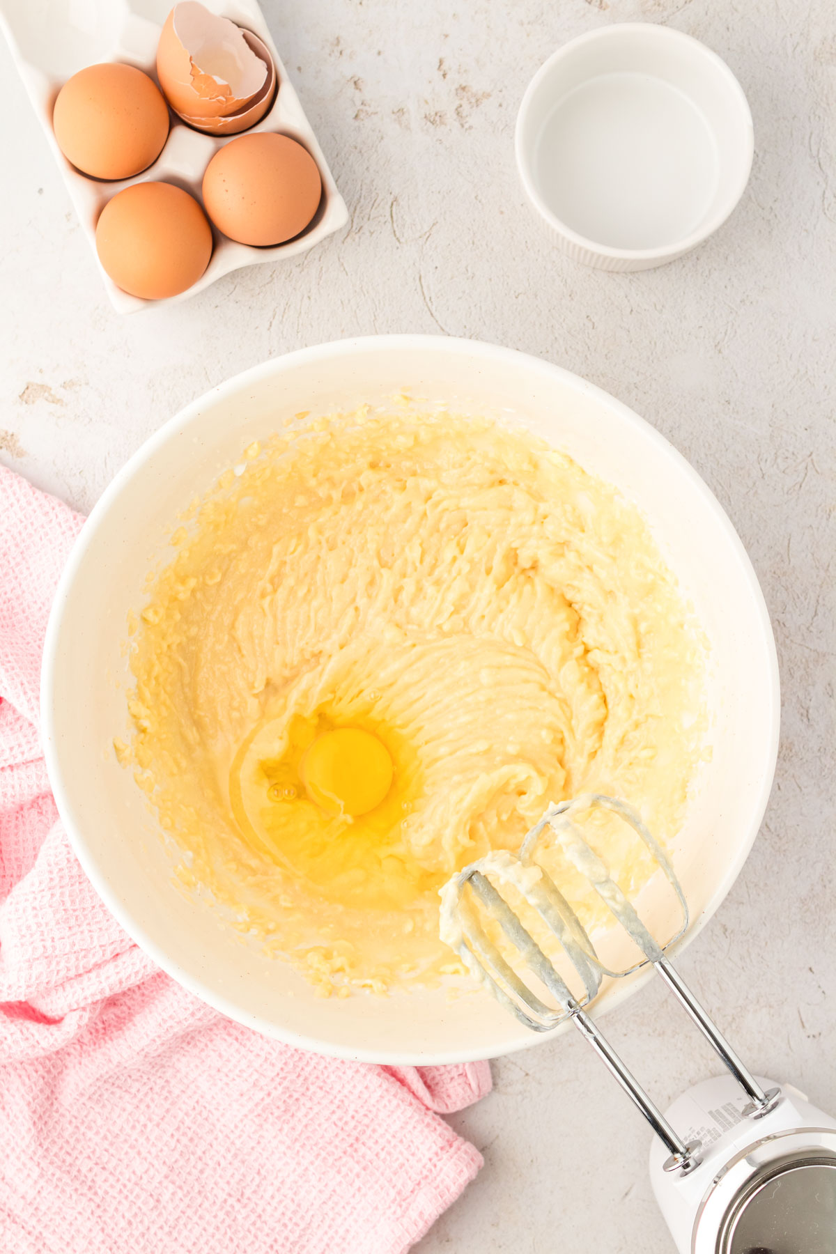 Egg being added to yellow cake mix.