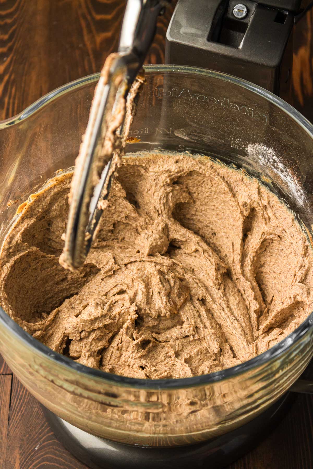 Peanut Butter cookie dough being made in a stand mixer.