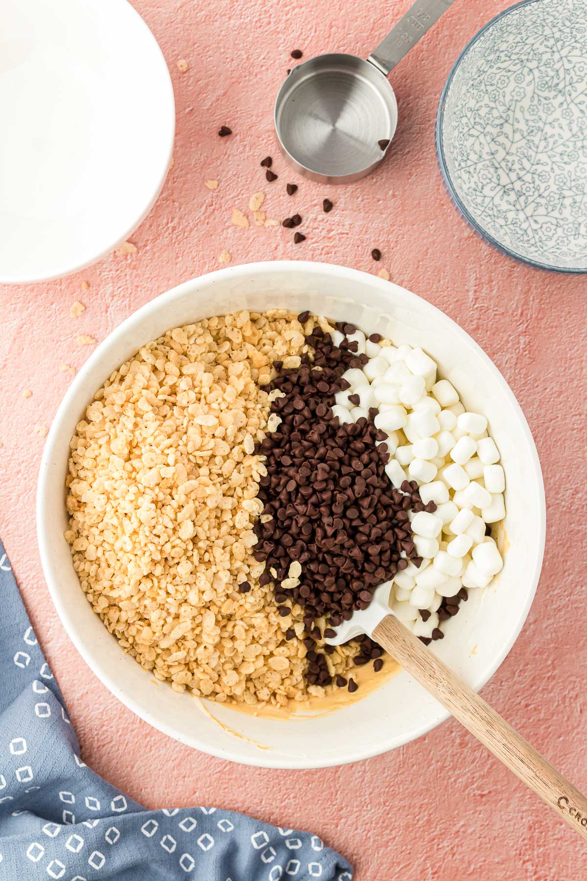 Rice krispies, chocolate chips, and mini marshmallows in a white bowl.
