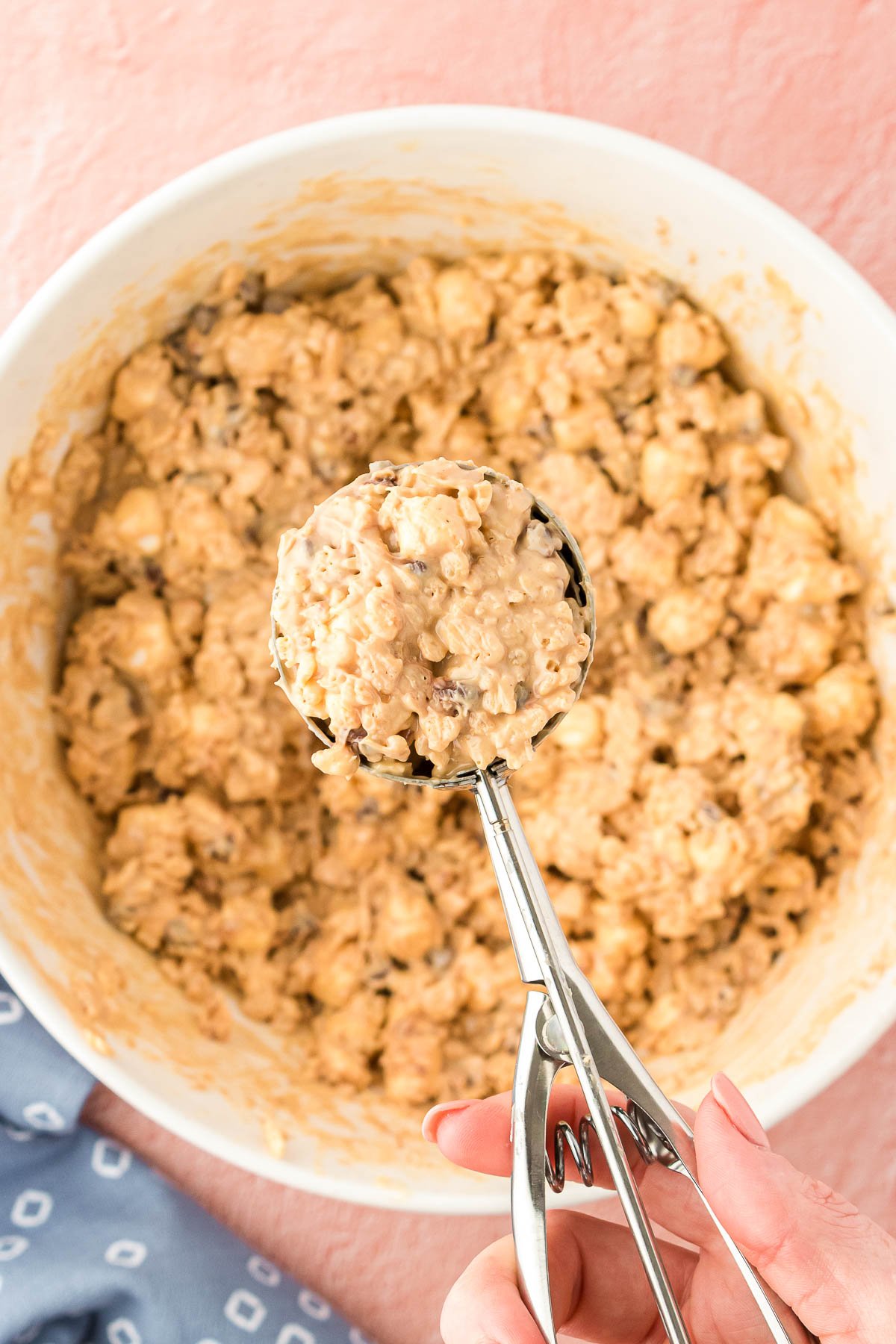 A cookie scoop scooping avalanche cookie mixture out of a bowl.