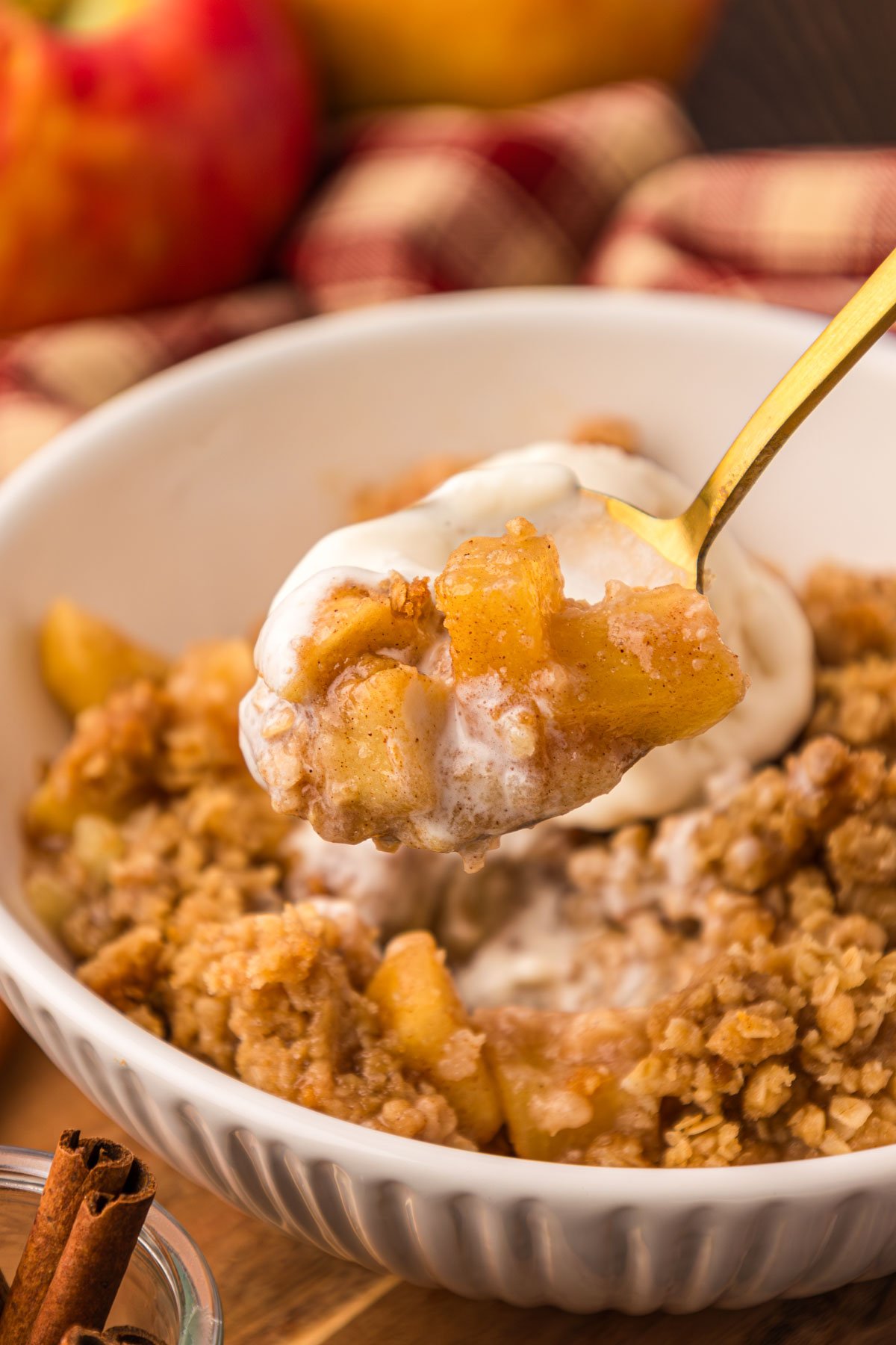 A spoon lifting a bite of apple crisp to the camera.