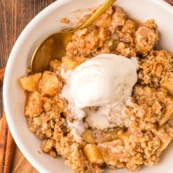 Overhead photo of a bowl of apple crisp with a scoop of ice cream on top.