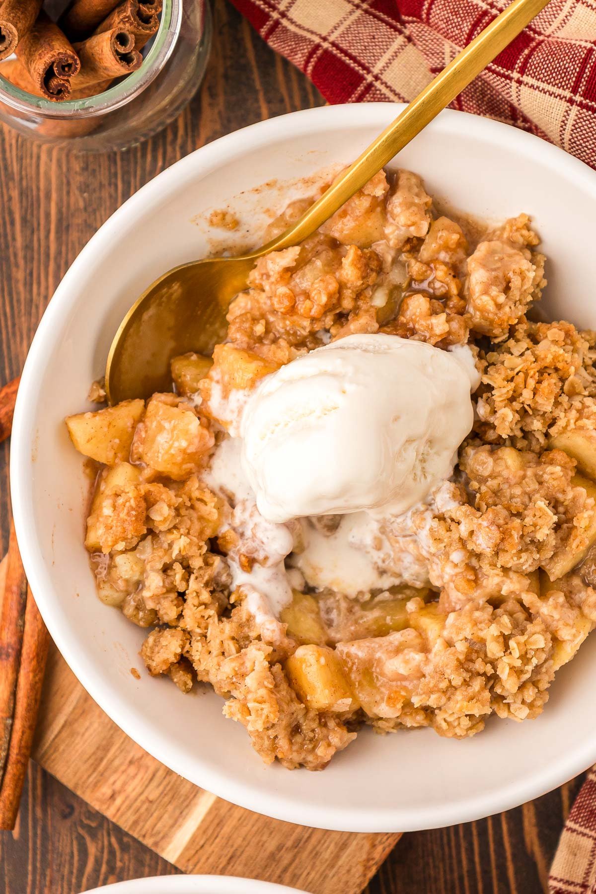 Overhead photo of a bowl of apple crisp with a scoop of ice cream on top.