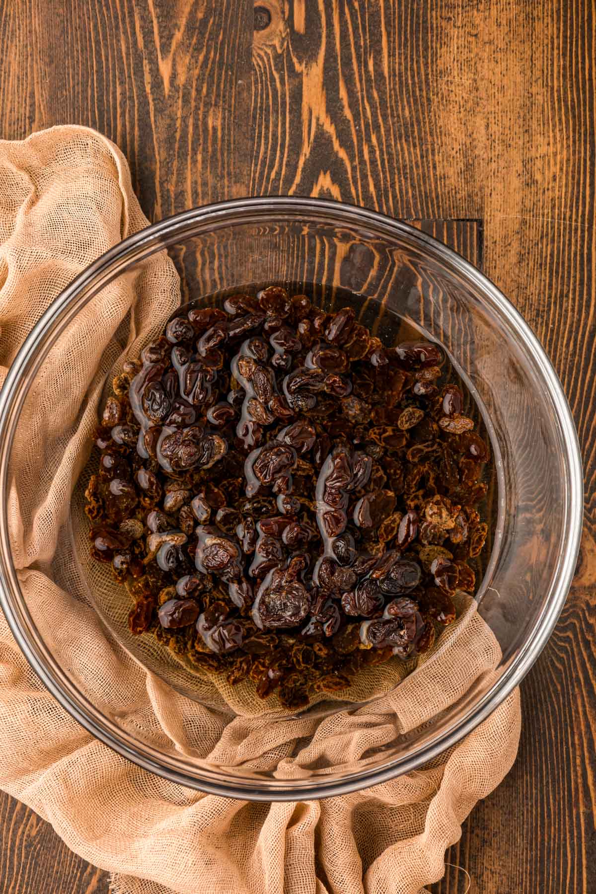 Raisins soaking in a bowl of hot water.