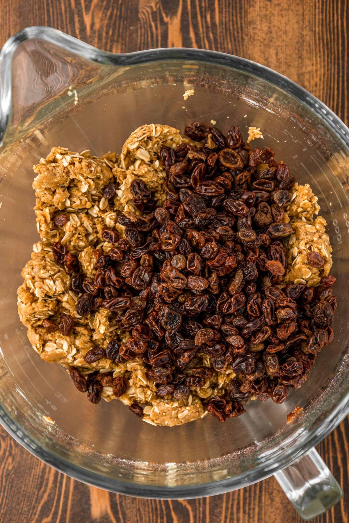 Raisins added to a bowl of oatmeal cookie dough.